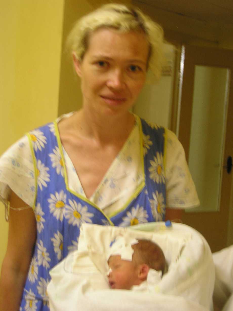 08  8 19  Dzina coaxed & almost smiles, standing behind Robert in nurse's hands RED60PCT  P8190036